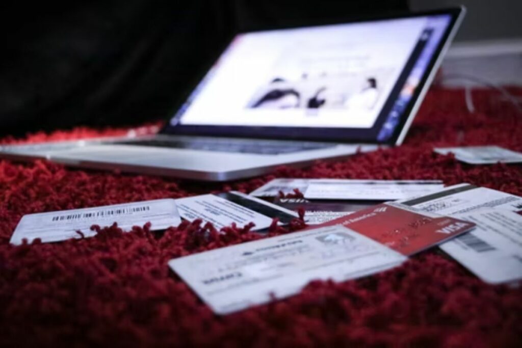 laptop con tarjetas sobre cama - Claro Shop